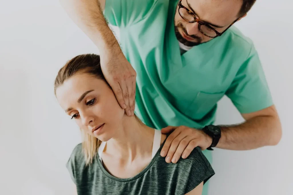 Healthcare professional performing a neck adjustment on a female patient during a chiropractic session.
